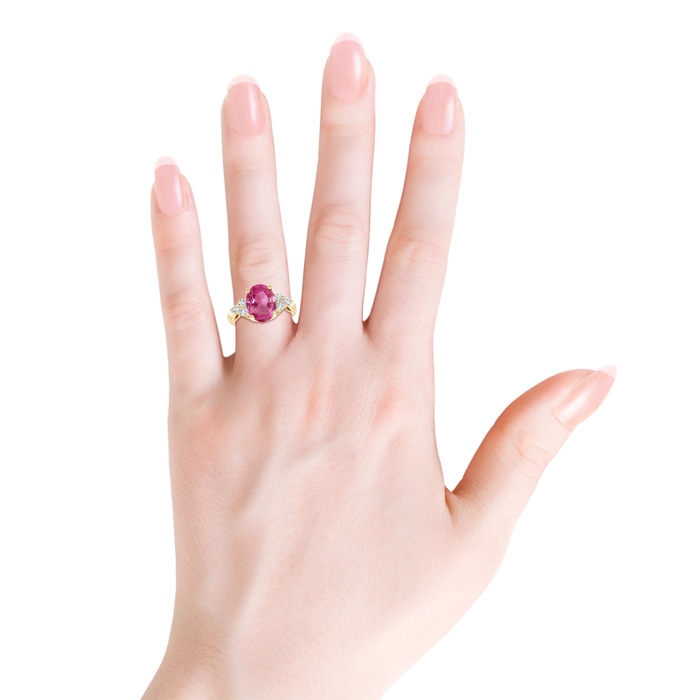 10x8mm AAAA Oval Pink Sapphire Cocktail Ring With Trio Diamond Accents in Yellow Gold Body-Hand