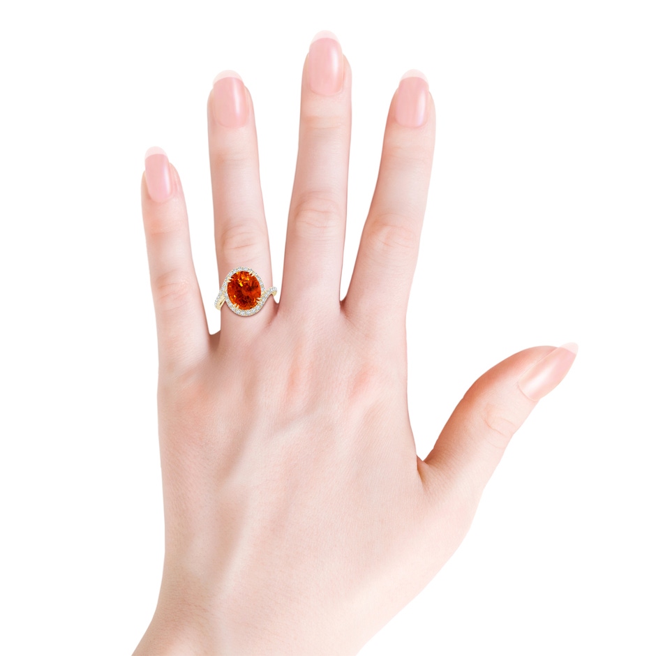 12.12x10.14x8.64mm AAAA GIA Certified Oval Orange Sapphire Bypass Shank Ring with Diamonds in 9K Yellow Gold body-hand